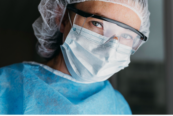 Cirurgião utilizando equipamentos de proteção em ambiente cirúrgico, representando segurança, controle e tecnologia avançada na cirurgia plástica.